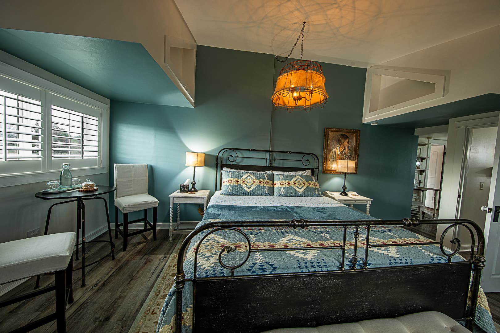 Sink into the king bed with designer bedding, The space carries a touch of French country farm style, creating a warm and restful retreat.