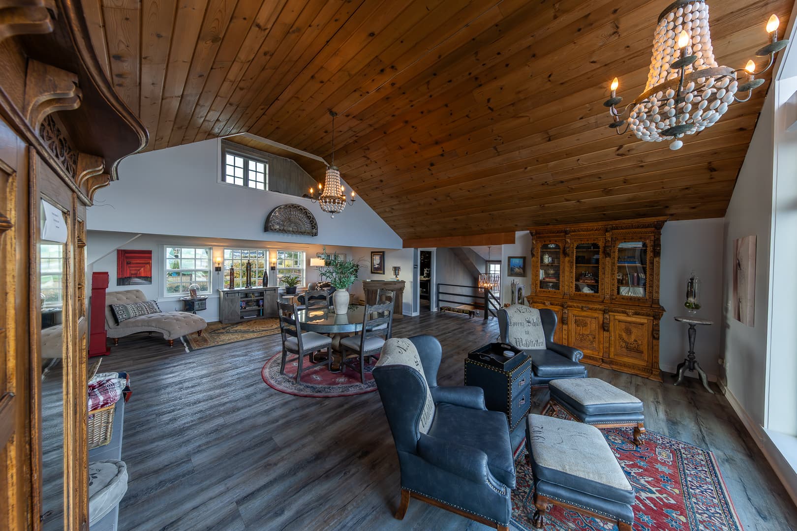 A spacious living area with wooden beams, elegant furnishings, and large windows.